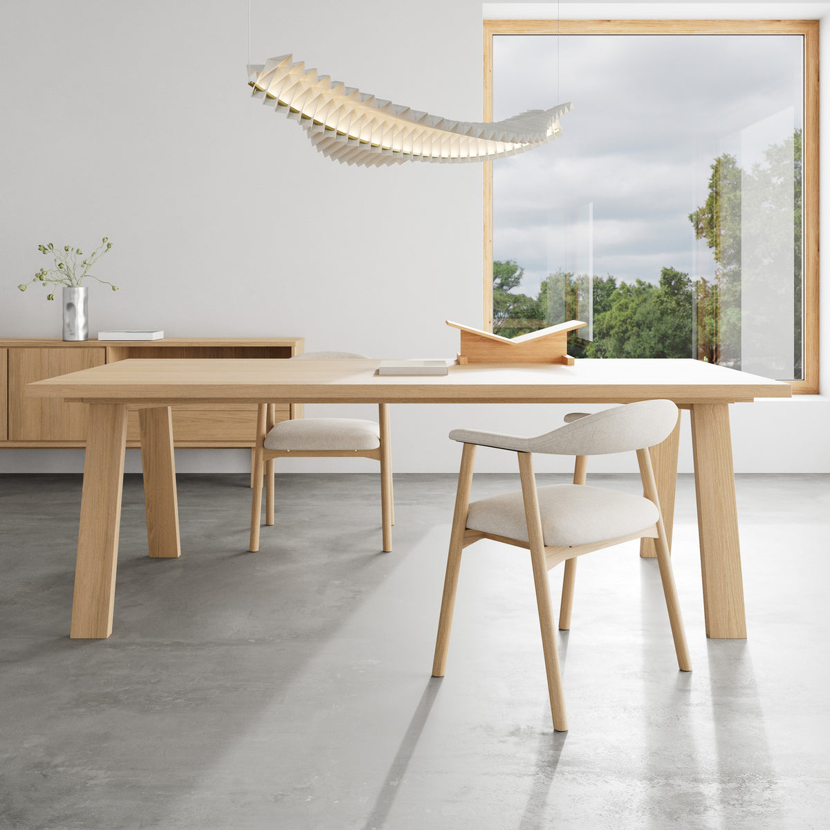 The Lurisse 220x100 table in a bright dining room with a large window, upholstered chairs and a pendant light – a dining table