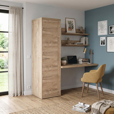 Korin wardrobe 201x57 in a bright room with a blue wall, next to shelves and an armchair – narrow wardrobe for a small flat