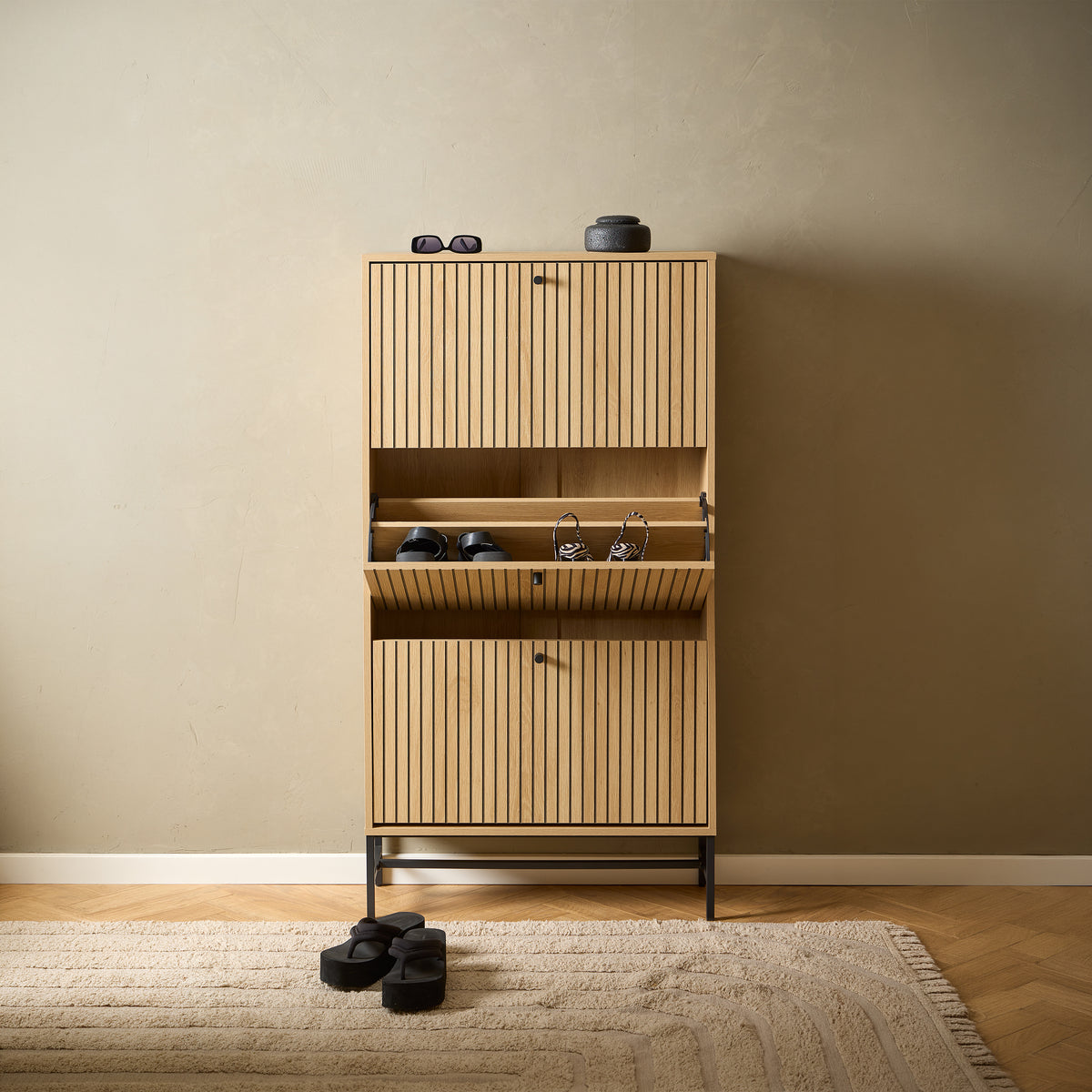 Bambouz 72x141 shoe cupboard in the hallway with a herringbone pattern – a central compartment with shoes that opens outwards, a rug and decorations