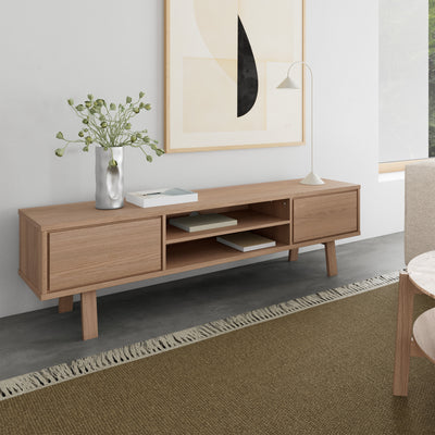 Lurisse TV cabinet, 180x50, bleached oak, in the living room beneath a print, with a lamp, a vase and books on an olive-coloured rug